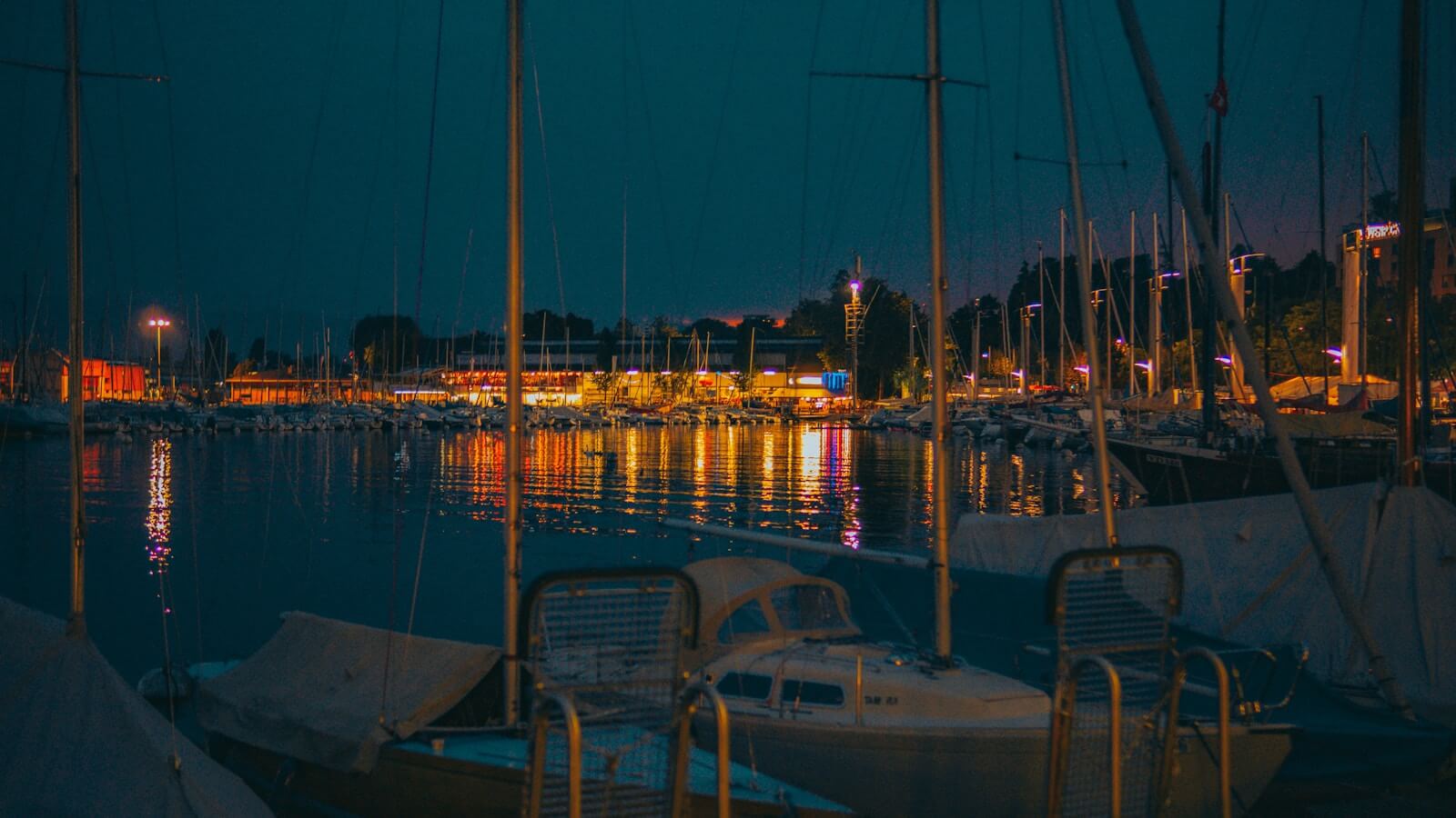 Photo by Renaldo Kodra Nighttime view of boats docked along a harbor.